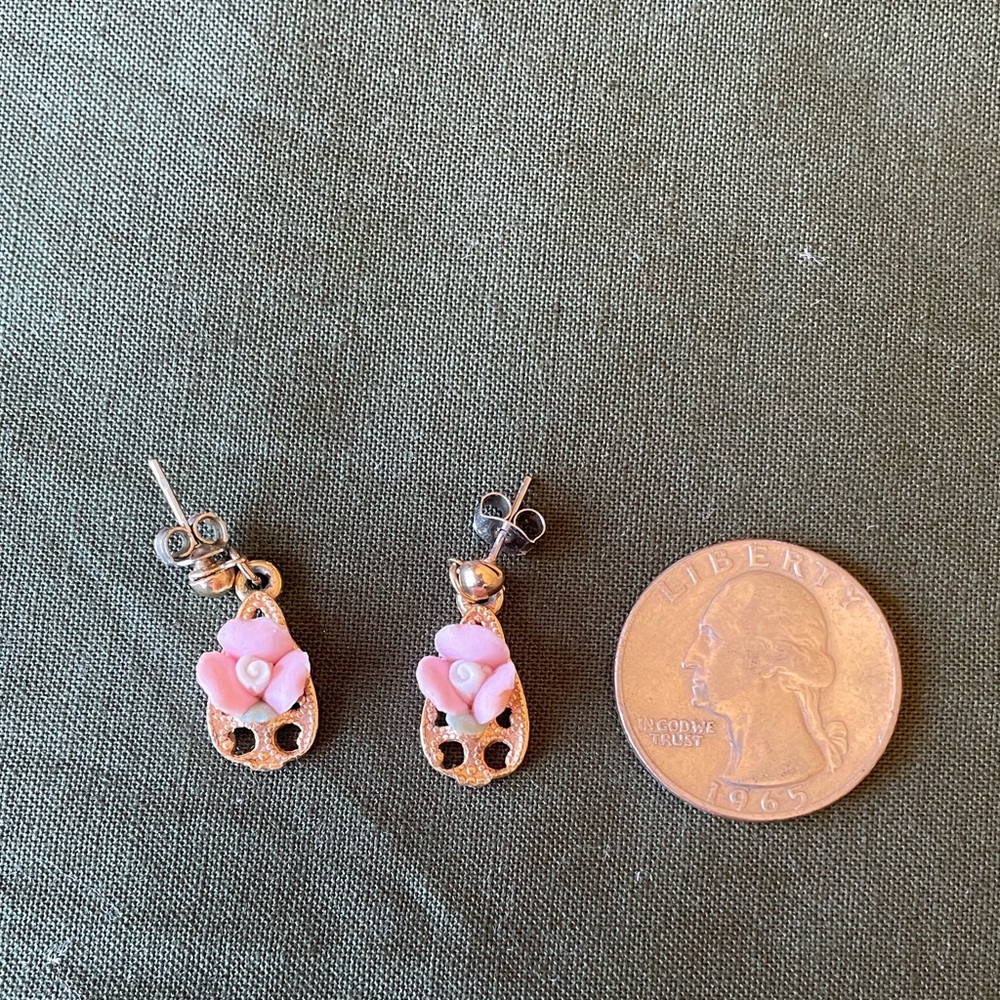 Vintage porcelain flower earrings on gold background.